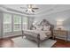 Bright main bedroom featuring a tray ceiling, neutral color palette, and large windows at 525 Morning Oaks Dr, Holly Springs, NC 27540