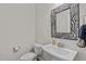 Clean powder room featuring a pedestal sink and modern mirror at 525 Morning Oaks Dr, Holly Springs, NC 27540
