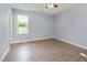 Bright bedroom featuring a ceiling fan, light gray walls, and luxury vinyl flooring with ample natural light at 5317 Cottage Bluff Ln, Knightdale, NC 27545