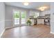Eat-in kitchen featuring white cabinets, wood-look floors, and stainless steel appliances at 5317 Cottage Bluff Ln, Knightdale, NC 27545