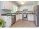 Modern kitchen featuring stainless steel appliances, white cabinets, and wood-look floors at 5317 Cottage Bluff Ln, Knightdale, NC 27545