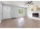 Bright living room with wood-look floors, a white fireplace, and a view of the front porch at 5317 Cottage Bluff Ln, Knightdale, NC 27545
