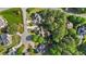 Aerial view of a home nestled among lush greenery, showcasing its backyard fire pit and tree-lined surroundings at 5705 Tannibark Ln, Fuquay Varina, NC 27526