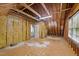 Unfinished attic space featuring exposed rafters, insulation, and a doorway, offering potential for customization at 5705 Tannibark Ln, Fuquay Varina, NC 27526