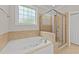 Bright bathroom featuring a soaking tub and glass-enclosed shower at 5705 Tannibark Ln, Fuquay Varina, NC 27526