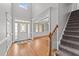 Grand foyer with hardwood floors, staircase, and a view into the formal dining room at 5705 Tannibark Ln, Fuquay Varina, NC 27526
