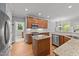 Modern kitchen featuring granite counters, stainless steel appliances, and hardwood floors at 5705 Tannibark Ln, Fuquay Varina, NC 27526