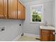 Functional laundry room with cabinets and sink, offering convenience and storage at 5705 Tannibark Ln, Fuquay Varina, NC 27526