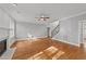 Open living room featuring hardwood floors, a cozy fireplace, and plenty of natural light at 5705 Tannibark Ln, Fuquay Varina, NC 27526