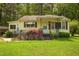Charming single-story home with yellow siding, a covered porch, and a lush flower bush at 5743 Craig Rd, Durham, NC 27712