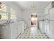 White kitchen features a classic design with vintage tile flooring and ample natural light at 5743 Craig Rd, Durham, NC 27712