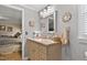 Bathroom vanity with neutral toned cabinets and view of the bedroom through an open door at 6237 Nc 96 Hwy W, Youngsville, NC 27596