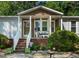 Close-up of the charming front porch with brick stairs and decorative plants at 6237 Nc 96 Hwy W, Youngsville, NC 27596
