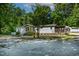 Home exterior with a small porch, green shrubbery, and treelined backdrop at 6237 Nc 96 Hwy W, Youngsville, NC 27596