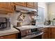 Close up of oven, countertop, range hood and backsplash in traditionally styled kitchen at 6237 Nc 96 Hwy W, Youngsville, NC 27596