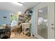 Bright laundry room with blue walls and window providing natural light, sink, storage shelves, and an exterior door at 6237 Nc 96 Hwy W, Youngsville, NC 27596
