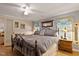 Comfortable bedroom featuring hardwood floors, large windows, decorative lamps, and stylish furniture at 6237 Nc 96 Hwy W, Youngsville, NC 27596