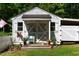 Charming outdoor shed featuring farmhouse-style doors, flower pots, and a welcoming wicker chair at 6237 Nc 96 Hwy W, Youngsville, NC 27596
