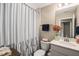 Bathroom features a toilet, sink, mirror, and shower with a striped curtain at 636 Copper Beech Ln, Wake Forest, NC 27587
