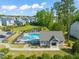 Community pool and recreational area featuring a clubhouse, lounge chairs, and a picturesque pond at 636 Copper Beech Ln, Wake Forest, NC 27587
