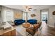 Bright living room featuring two blue sofas, wood floors, and large windows at 636 Copper Beech Ln, Wake Forest, NC 27587
