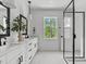 Bright bathroom features dual sinks, white cabinetry, and a modern glass-enclosed shower at 6416 Tanner Oak Ln, Raleigh, NC 27613