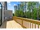 Outdoor deck with wooded view, seating and wooden railing at 6416 Tanner Oak Ln, Raleigh, NC 27613