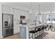 Open-concept kitchen with white cabinets, stainless steel appliances, and an island with seating at 6416 Tanner Oak Ln, Raleigh, NC 27613
