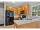 A well-lit kitchen features wooden cabinets, sleek black appliances, and ample counter space for cooking prep at 7019 Bellard Ct, Raleigh, NC 27617
