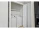 A compact laundry area complete with a washer, dryer, and shelving for added storage at 7019 Bellard Ct, Raleigh, NC 27617