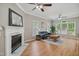 Spacious living room with fireplace, hardwood floors, and abundant natural light from large windows at 7019 Bellard Ct, Raleigh, NC 27617