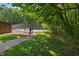 Tennis court is surrounded by trees, offering a secluded playing experience at 7019 Bellard Ct, Raleigh, NC 27617
