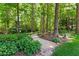 Beautiful landscaped backyard with stone walkway and mature trees at 7212 Donneeford Rd, Wake Forest, NC 27587