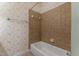 A traditional bathroom featuring a white bathtub with beige tile surround and patterned wallpaper at 7212 Donneeford Rd, Wake Forest, NC 27587
