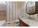 Bathroom with granite countertops, oval mirror, decorative wallpaper, and tiled shower/bath at 7212 Donneeford Rd, Wake Forest, NC 27587