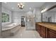 Bright bathroom showcases a glass enclosed shower, tub, chandelier, and double vanity at 7212 Donneeford Rd, Wake Forest, NC 27587