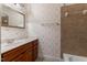 Traditional bathroom with a single sink vanity, floral wallpaper and a tiled shower and tub at 7212 Donneeford Rd, Wake Forest, NC 27587