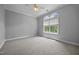Bright bedroom featuring soft carpet and a large window with views of lush landscaping at 7212 Donneeford Rd, Wake Forest, NC 27587
