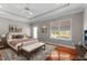 Virtually staged bedroom with hardwood floors, neutral walls, recessed lighting, and tray ceiling detail at 7212 Donneeford Rd, Wake Forest, NC 27587