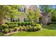 Landscaped front yard with mature trees, shrubbery, and a brick-laid walkway to the front door at 7212 Donneeford Rd, Wake Forest, NC 27587