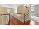Hardwood hallway with white rails, light sconce, and an open doorway at 7212 Donneeford Rd, Wake Forest, NC 27587