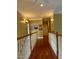 Hallway with hardwood floors, white railings, overhead lighting, and decorative pictures at 7212 Donneeford Rd, Wake Forest, NC 27587