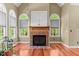 Inviting living room with fireplace, built-ins, and arched windows for natural light at 7212 Donneeford Rd, Wake Forest, NC 27587