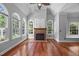 Cozy living room with vaulted ceilings, a decorative ceiling fan, a fireplace, and arched windows at 7212 Donneeford Rd, Wake Forest, NC 27587