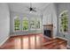 Bright living room with arched windows, a ceiling fan, a fireplace, and hardwood floors at 7212 Donneeford Rd, Wake Forest, NC 27587