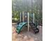 Community playground with a green, white and black metal playset surrounded by trees at 7212 Donneeford Rd, Wake Forest, NC 27587