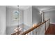 Elegant staircase with stained-glass window, chandelier, and hardwood floors adding a touch of classic charm at 7212 Donneeford Rd, Wake Forest, NC 27587