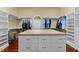 Spacious walk-in closet with custom shelving, island with drawers and a bright window for natural lighting at 7212 Donneeford Rd, Wake Forest, NC 27587