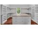 Large walk-in closet with hardwood floors, custom shelves, and an island with drawers at 7212 Donneeford Rd, Wake Forest, NC 27587