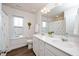Bright bathroom with double sinks, wood-look flooring, and white cabinets at 73 Windswept Way, Fuquay Varina, NC 27526